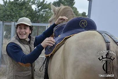 Mario Pérez Langa preparando a su caballo junto a un colaborador, mostrando el cuidado y dedicación hacia su compañero de faena.